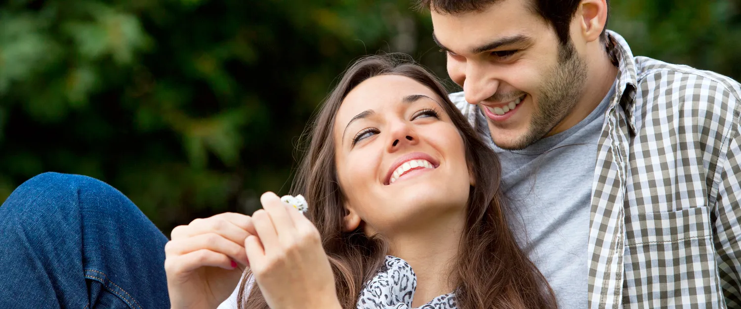 A smiling couple sitting together outdoors